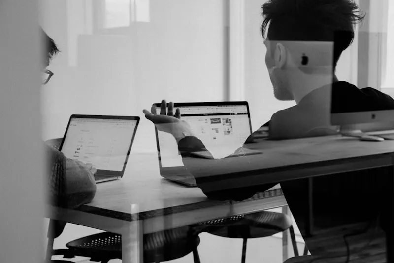 Two people discussing a digital product at a work table